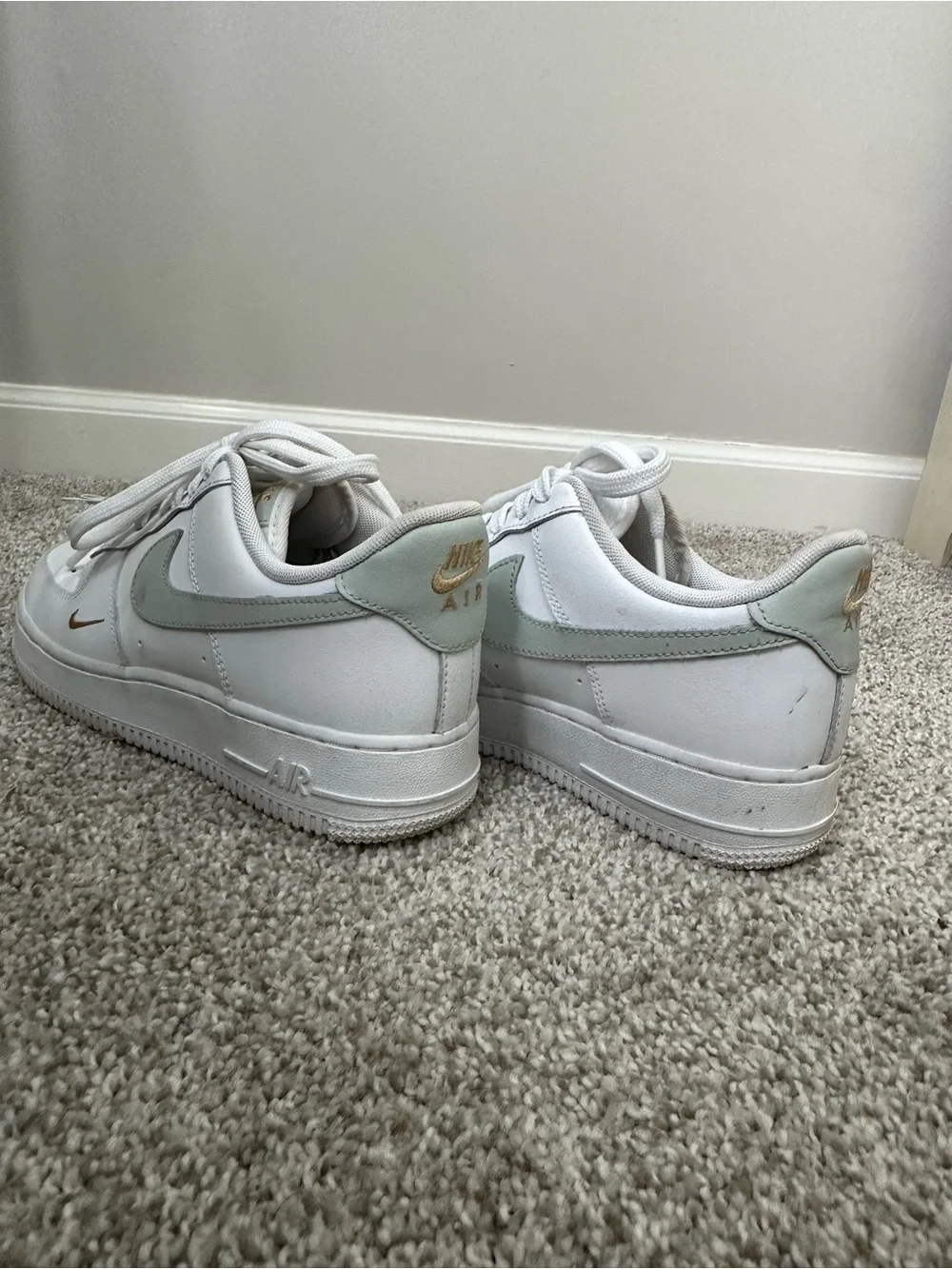 Nike White Sneakers with Sage Green Swoosh and Gold Accent